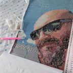 Toile de diamond painting personnalisée en cours de montage : portrait en diamants carrés, stylo applicateur et sachets de diamants numérotés
